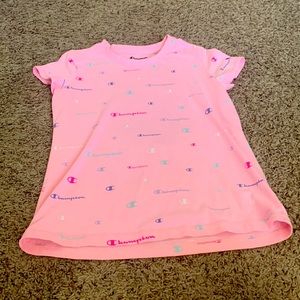 Pink Champion Shirt with different color logos on it.